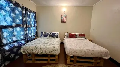 two twin beds in a room with a window at Kwetu Villa in Arusha