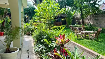 a garden with a table and chairs and plants at Kwetu Villa in Arusha
