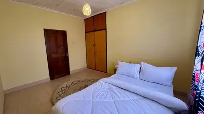 a bedroom with a bed with blue blankets and pillows at Kwetu Villa in Arusha