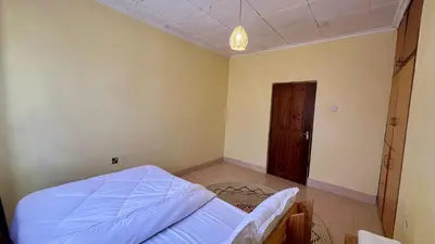a bedroom with a bed and a wooden door at Kwetu Villa in Arusha