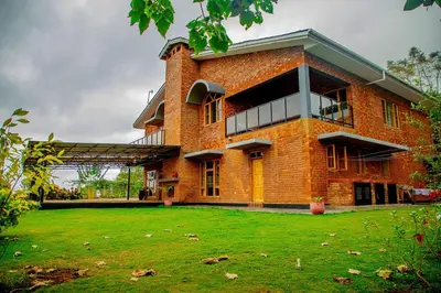 a large brick building with a green lawn in front of it at Tranquil Hillhouse in Nkoanrua