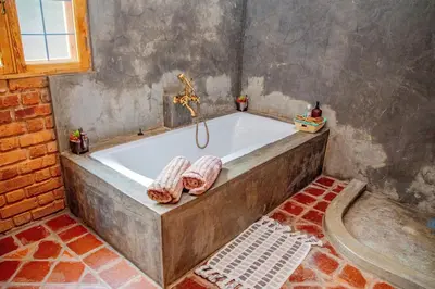 a bathroom with a tub with two towels on it at Tranquil Hillhouse in Nkoanrua