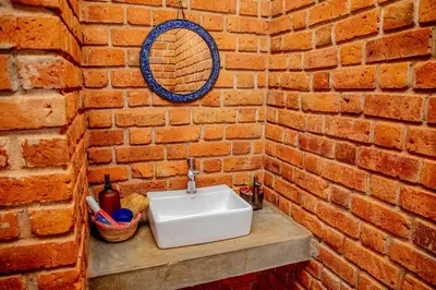 a bathroom with a sink in a brick wall at Tranquil Hillhouse in Nkoanrua