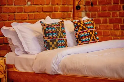a bed with four pillows on top of it at Tranquil Hillhouse in Nkoanrua