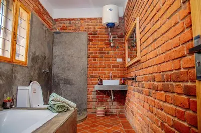 a bathroom with a brick wall and a bath tub at Tranquil Hillhouse in Nkoanrua