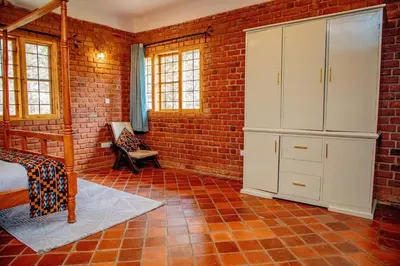a bedroom with a bed and a brick wall at Tranquil Hillhouse in Nkoanrua