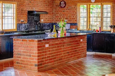 a kitchen with a brick wall and a brick counter at Tranquil Hillhouse in Nkoanrua