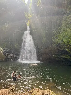 two people swimming in the water in front of a waterfall at 1 Bedroom- Tranquil Meru Retreat in Nkoanrua