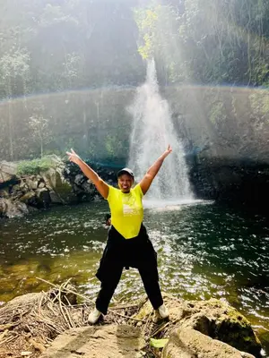 a man standing on a rock in front of a waterfall at 1 Bedroom- Tranquil Meru Retreat in Nkoanrua