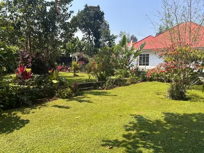 a yard with a house with a lot of flowers at 1 Bedroom- Tranquil Meru Retreat in Nkoanrua