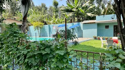 a yard with a pool and a house with a fence at Runako Lodge in Arusha