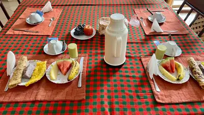 a table with plates of food and a bottle of milk at Runako Lodge in Arusha