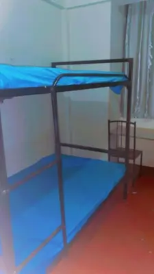 two bunk beds with blue sheets in a room at Kyanga Hostel in Arusha