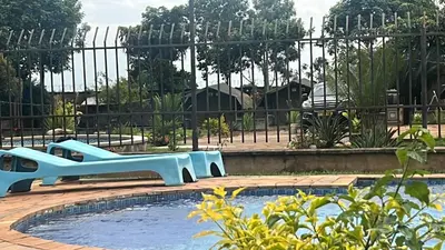 a swimming pool with a blue slide in front of a fence at Lufo Heritage Farm - Octavian Mshiu Residence in Uru
