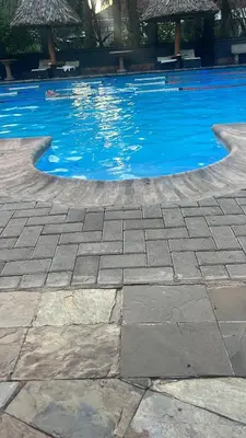 a swimming pool with blue water in a resort at Lufo Heritage Farm - Octavian Mshiu Residence in Uru