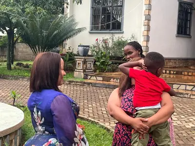 a group of women standing around a woman holding a child at Lufo Heritage Farm - Octavian Mshiu Residence in Uru