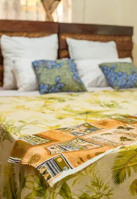 a bed with a colorful comforter on top of it at Ukarimu Hosts in Arusha