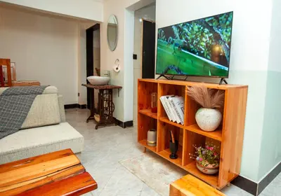 a living room with a flat screen tv on a entertainment center at Ukarimu Hosts in Arusha