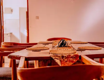 a wooden table with chairs and a table cloth on it at Avana Home in Arusha