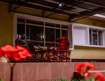 a pair of red chairs sitting on a porch at Avana Home in Arusha