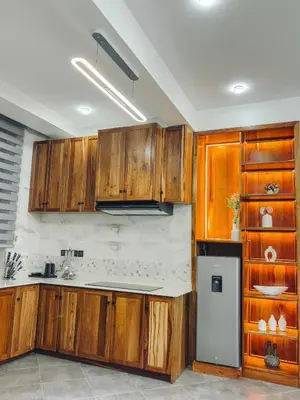 a kitchen with wooden cabinets and a refrigerator at Valonia Apartments in Arusha