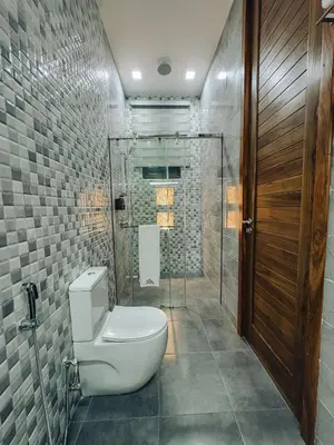 a bathroom with a toilet and a glass shower at Valonia Apartments in Arusha