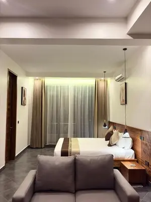 a hotel room with a bed and a couch at Valonia Apartments in Arusha