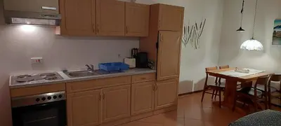 a kitchen with wooden cabinets and a table with a table at Haika Georges' Homestay in Arusha
