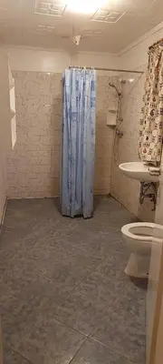 a bathroom with a toilet and a shower at Haika Georges' Homestay in Arusha