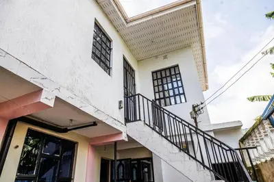 a white house with a staircase in front of it at lioness villa homestay in Arusha
