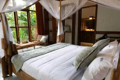 a bedroom with a large bed with white sheets and pillows at Arusha Explorers Lodge in Themi