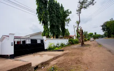 a house with a fence on the side of the road at Enamour Moshi in Moshi