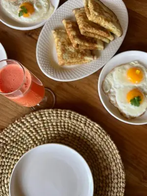 a table topped with plates of eggs and toast at Our Stay Mlima in Arusha