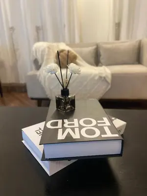 a book on a table with a vase on top at Rhovee Arusha in Arusha