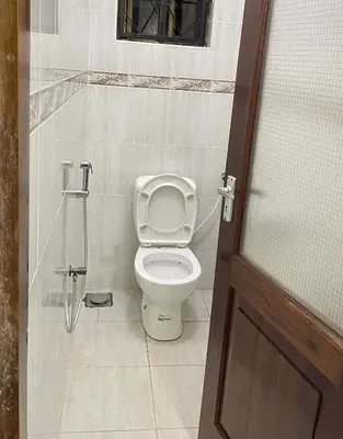 a bathroom with a toilet and a shower stall at Rhovee Arusha in Arusha