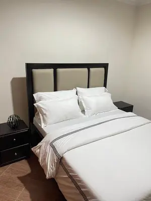 a large bed with white sheets and pillows on it at Rhovee Arusha in Arusha