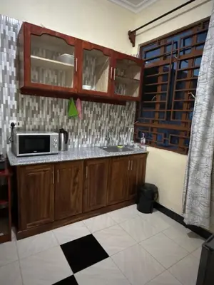 a kitchen with a sink and a microwave at Fatoosh Nest in Arusha