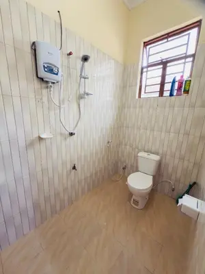 a bathroom with a toilet and a shower at Fatoosh Nest in Arusha