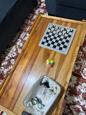 a chess game on a wooden table with glasses and a chessboard at Fatoosh Nest in Arusha