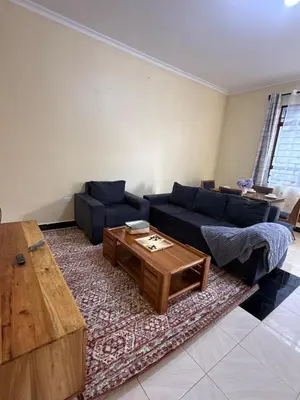 a living room with a blue couch and a coffee table at Fatoosh Nest in Arusha