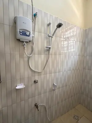 a shower in a bathroom with a shower head at Fatoosh Nest in Arusha
