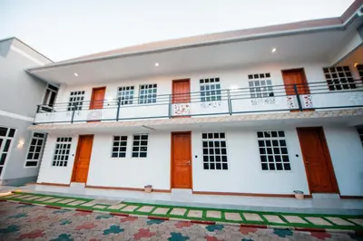 a white building with wooden doors and a balcony at Heaven Hill Apartments - Arusha in Arusha