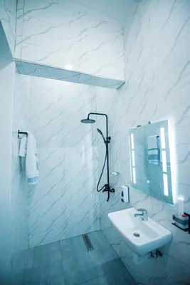 a white bathroom with a sink and a mirror at Heaven Hill Apartments - Arusha in Arusha