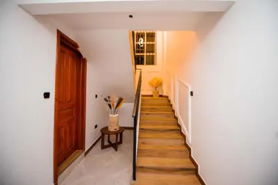 a staircase in a house with a wooden door at Heaven Hill Apartments - Arusha in Arusha