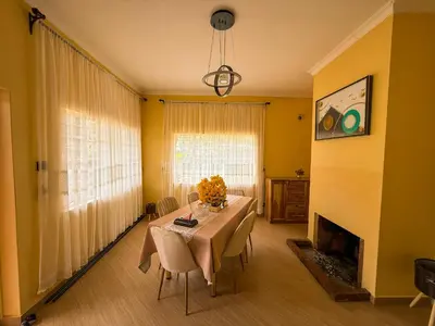 a dining room with a table and a fireplace at Nice & Slow Homes in Arusha