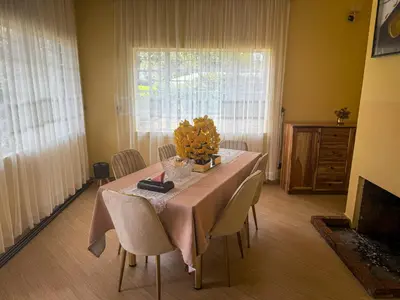 a dining room table with a vase of flowers on it at Nice & Slow Homes in Arusha