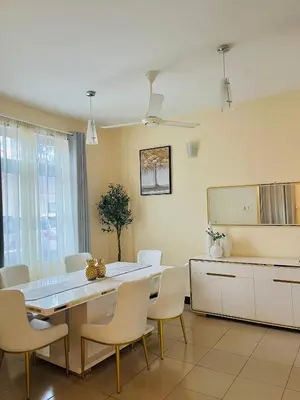 a dining room with a table and chairs at QD Apartment in Arusha