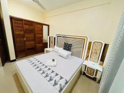 a bedroom with a large white bed in a room at QD Apartment in Arusha