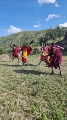 a group of people running in a field at Maasai Sacred Site - Africa Amini Life in Ngare Nanyuki