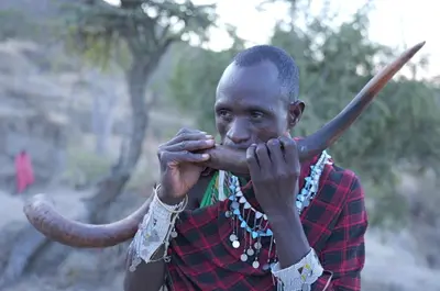 a man with an elephant trunk on his face at Maasai Sacred Site - Africa Amini Life in Ngare Nanyuki